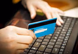 Hands holding a credit card over a keyboard