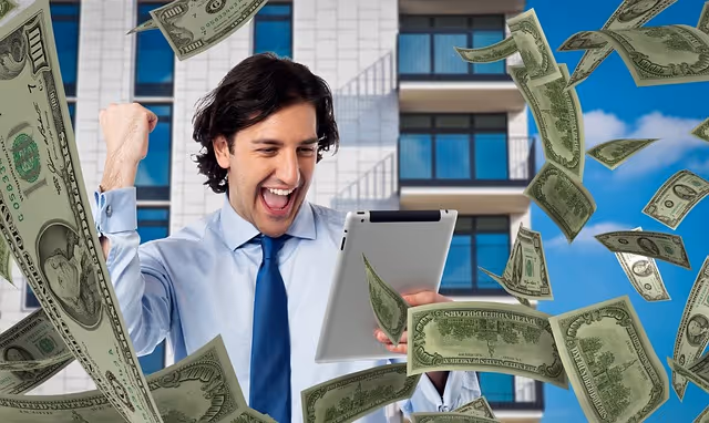 Excited man with tablet under falling dollar bills