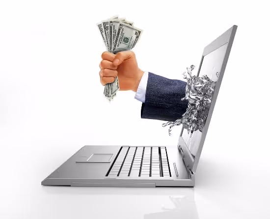 Hand with cash emerging from a laptop