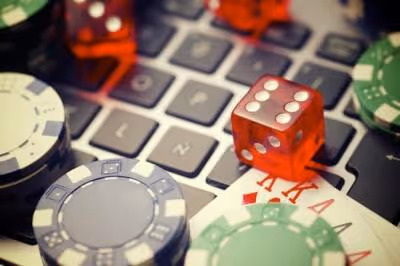 Dice, cards, and casino chips on a laptop keyboard